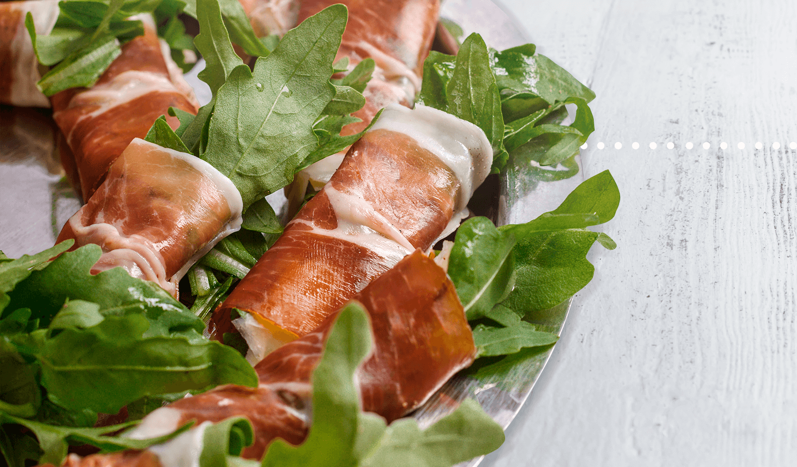 Una tabla con melón y Jamón de Cebo de Campo 50% Cortado a Cuchillo